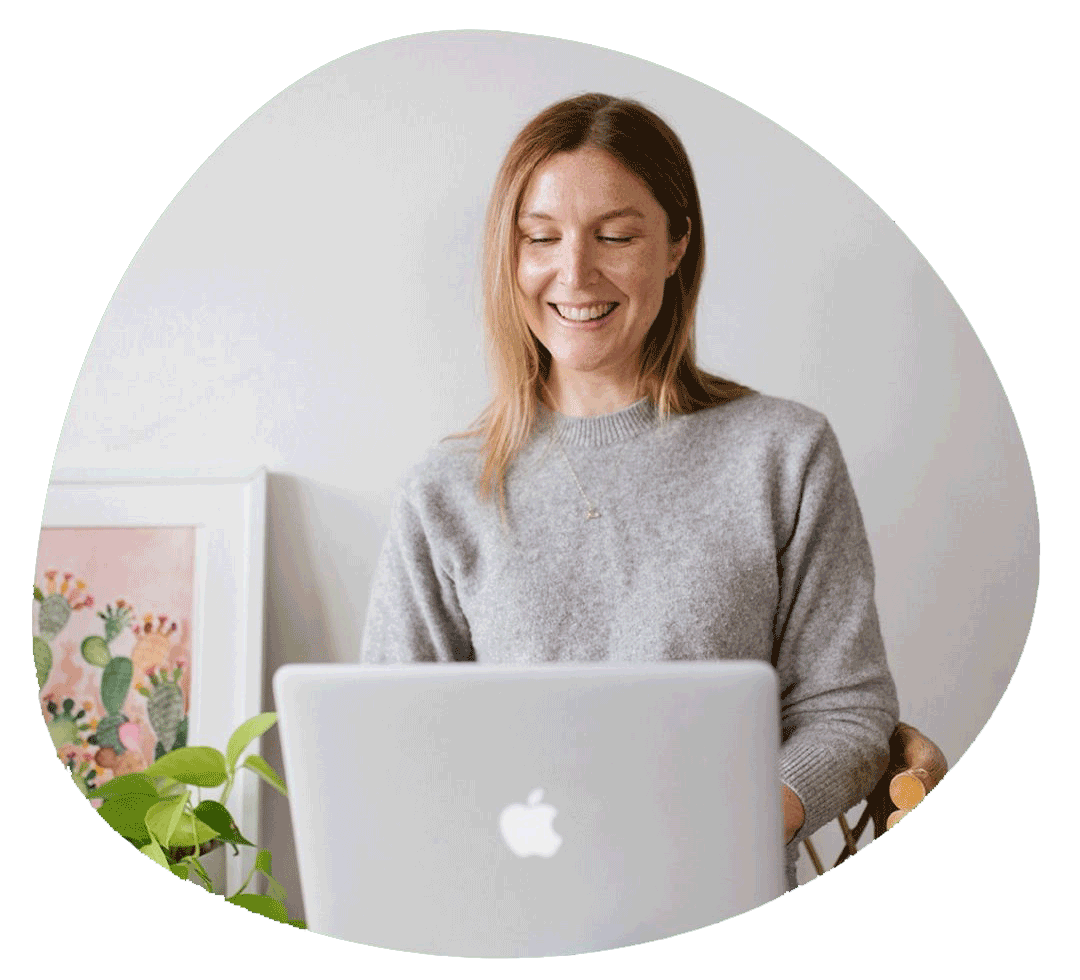 An image of Natalie typing on her laptop for the business blog, shes smiling and is wearing a light grey jumper. This business blog shares insights to improve your website engagement, brand design and reach online.